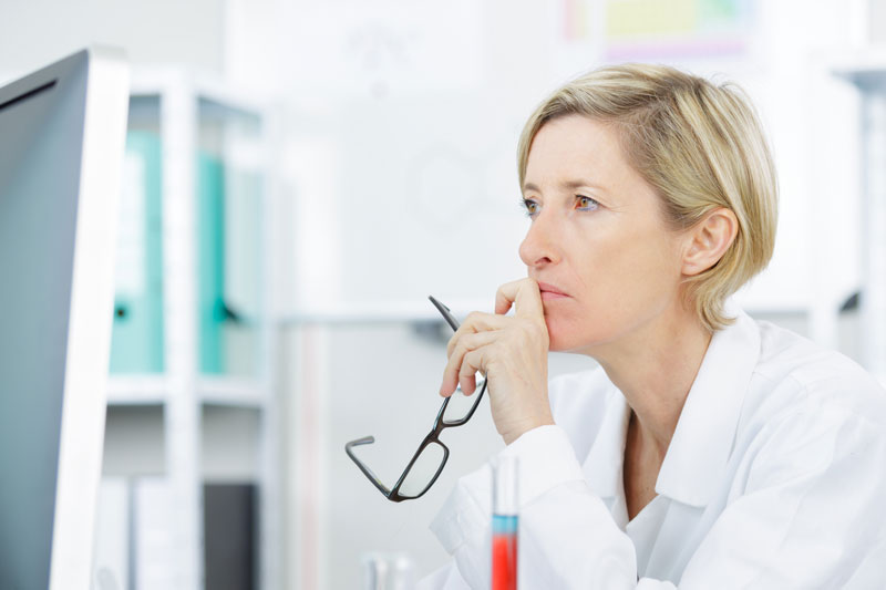 scientist looks serious with eyeglasses pulled off of face