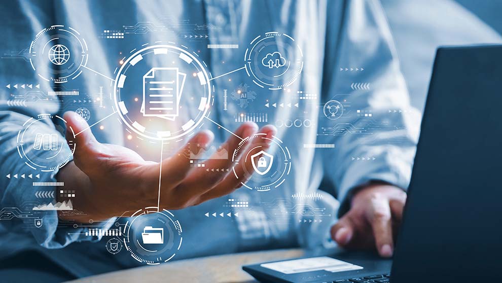 worker sits at laptop with graphic of server and file icons